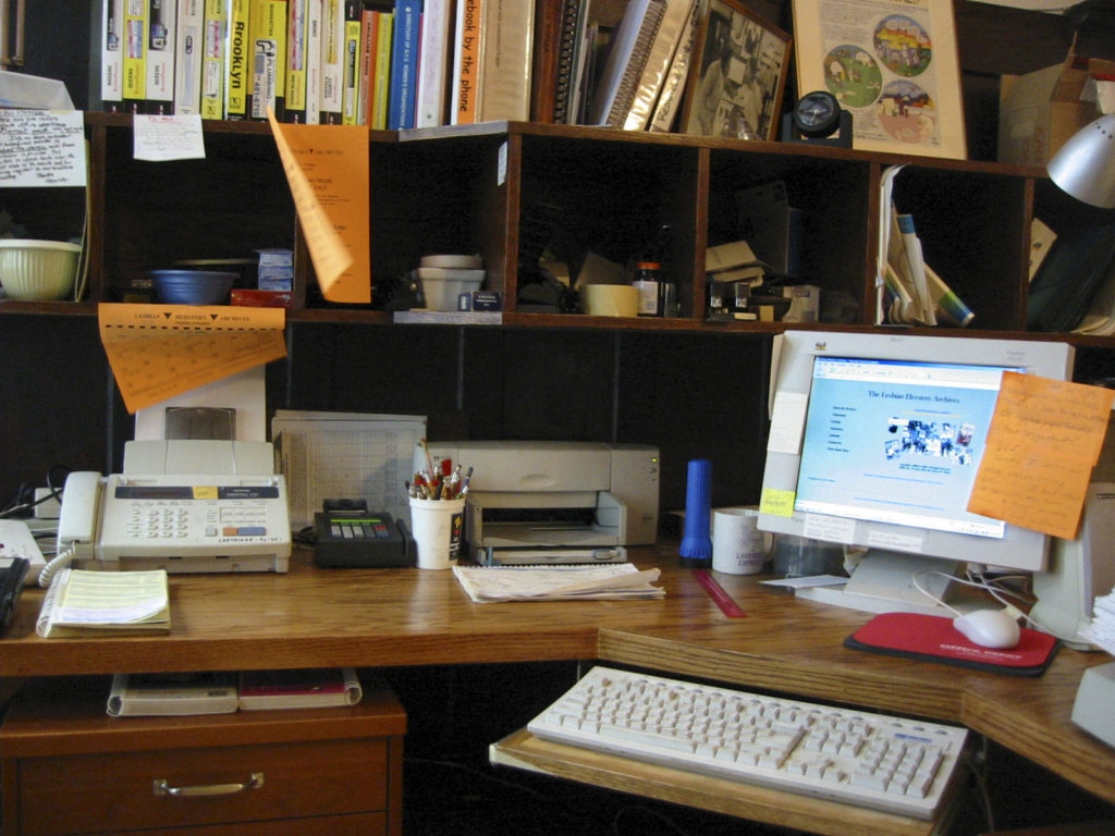 An organized workspace with a very old version of the LHA website up on a desktop computer screen